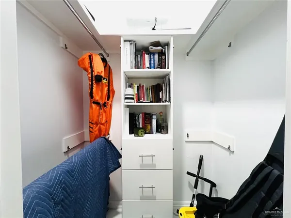 a view of walk in closet with clothes and shoes