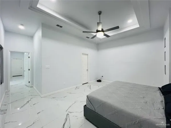 a spacious bedroom with a bed and a ceiling fan