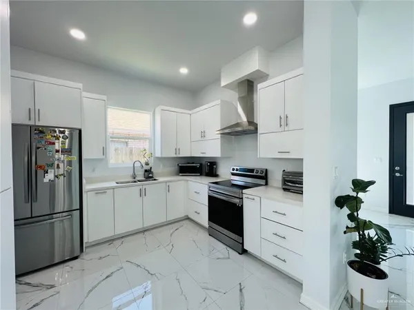 a kitchen with white cabinets stainless steel appliances and a window