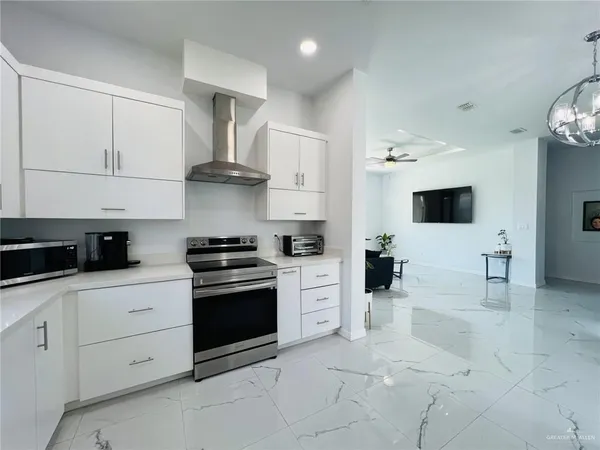a kitchen with stainless steel appliances granite countertop a refrigerator and a stove top oven