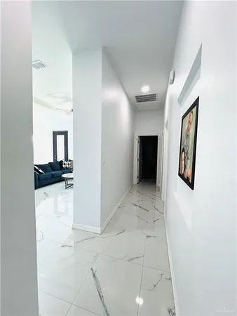 a view of a hallway with wooden floor and furniture
