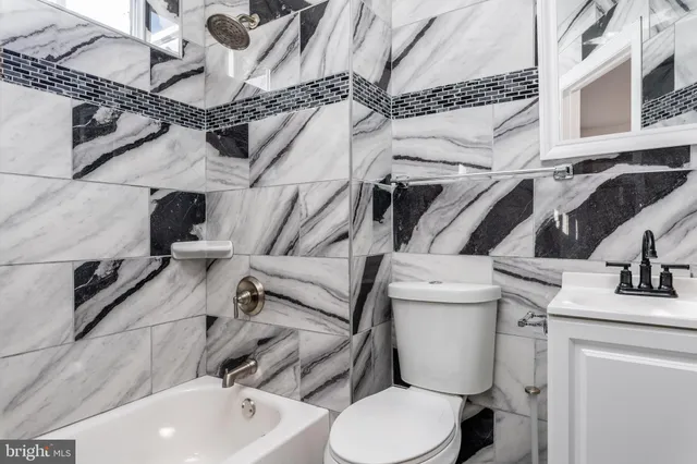 a bathroom with a sink mirror vanity and toilet
