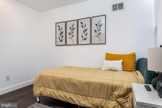 a bedroom with a bed a flat screen tv and a window