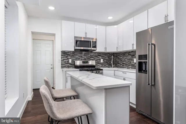 a kitchen with stainless steel appliances a refrigerator stove microwave and cabinets