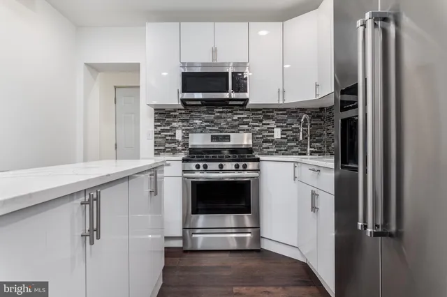 a kitchen with stainless steel appliances a stove microwave and sink