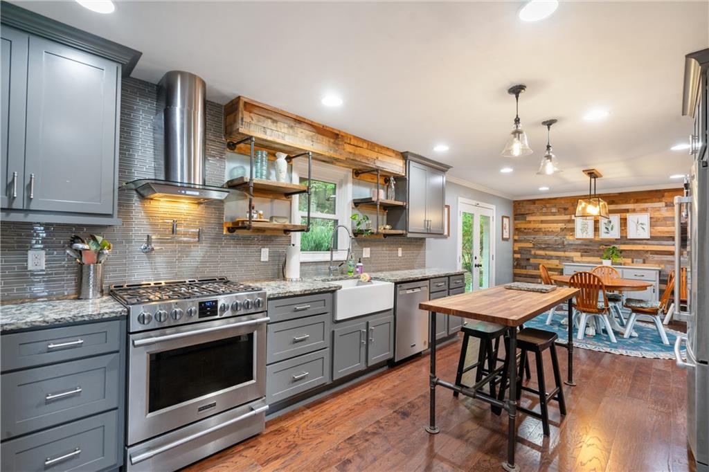 127 Berwyn Road Pittsburgh, PA 15237 - Photo 11 of 29 a kitchen with stainless steel appliances kitchen island granite countertop a stove top oven a sink a dining table and chairs with wooden floor