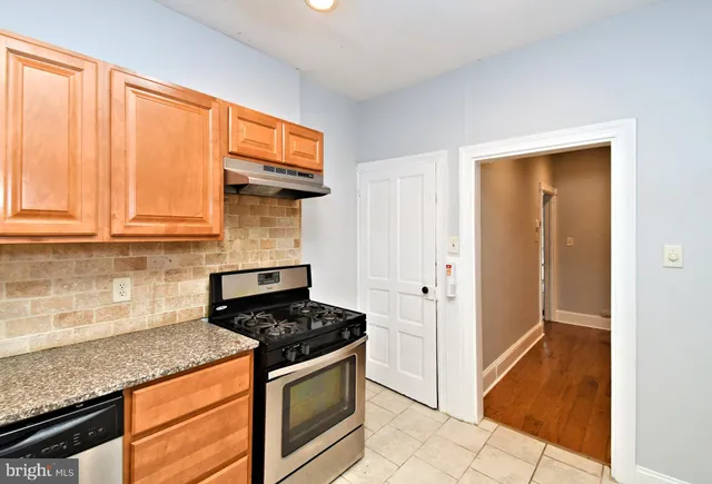 a stove top oven sitting inside of a kitchen