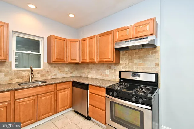 a kitchen with stainless steel appliances a stove a sink and a microwave