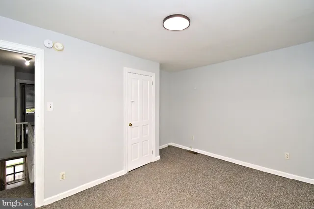 an empty room with wooden floor and window