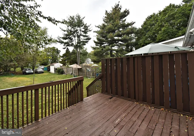 a wooden deck with trees in front of it