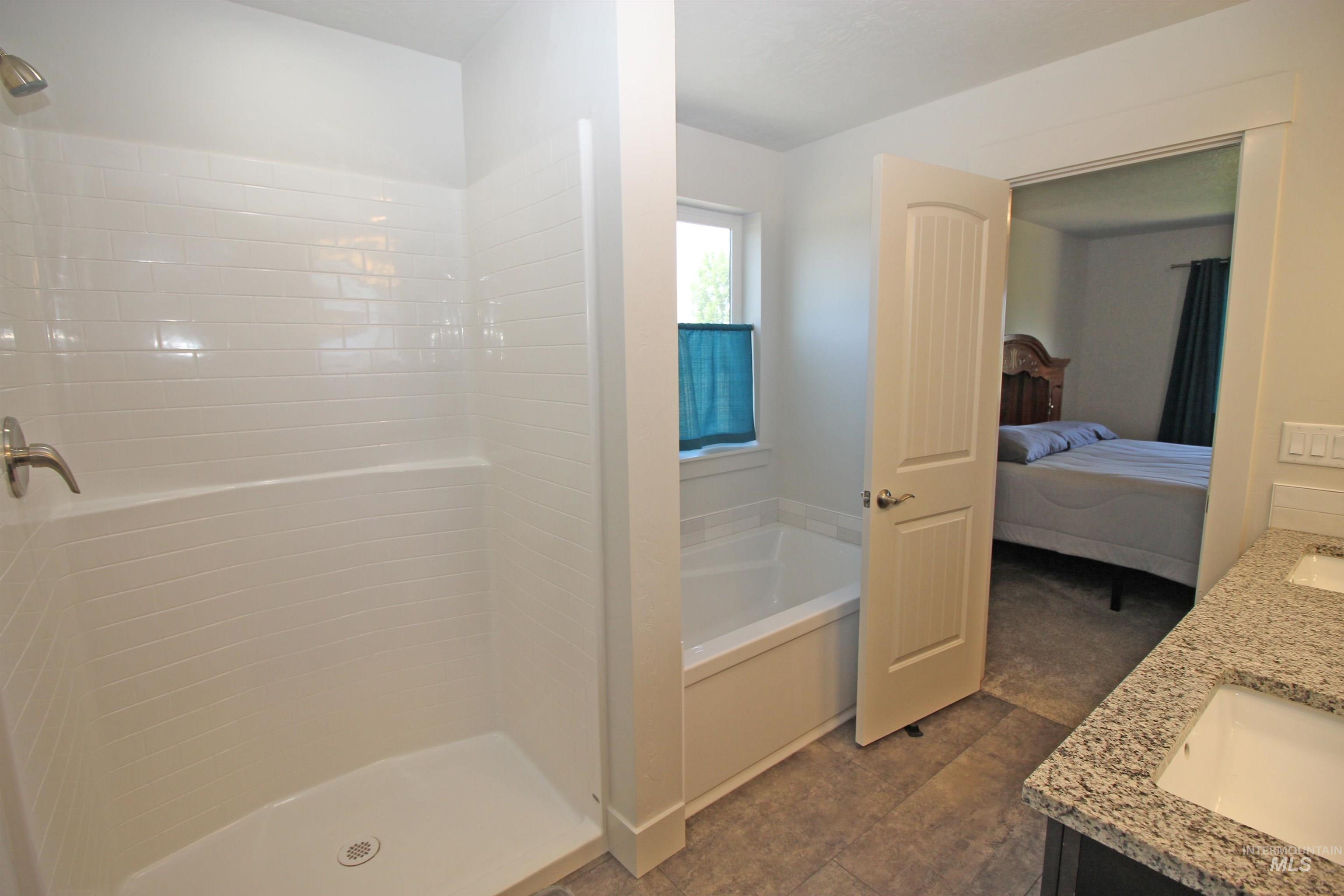 2272 Golf Lane Council, ID 83612 - Photo 17 of 32 Ensuite bathroom featuring double vanity, a garden tub, and walk in shower