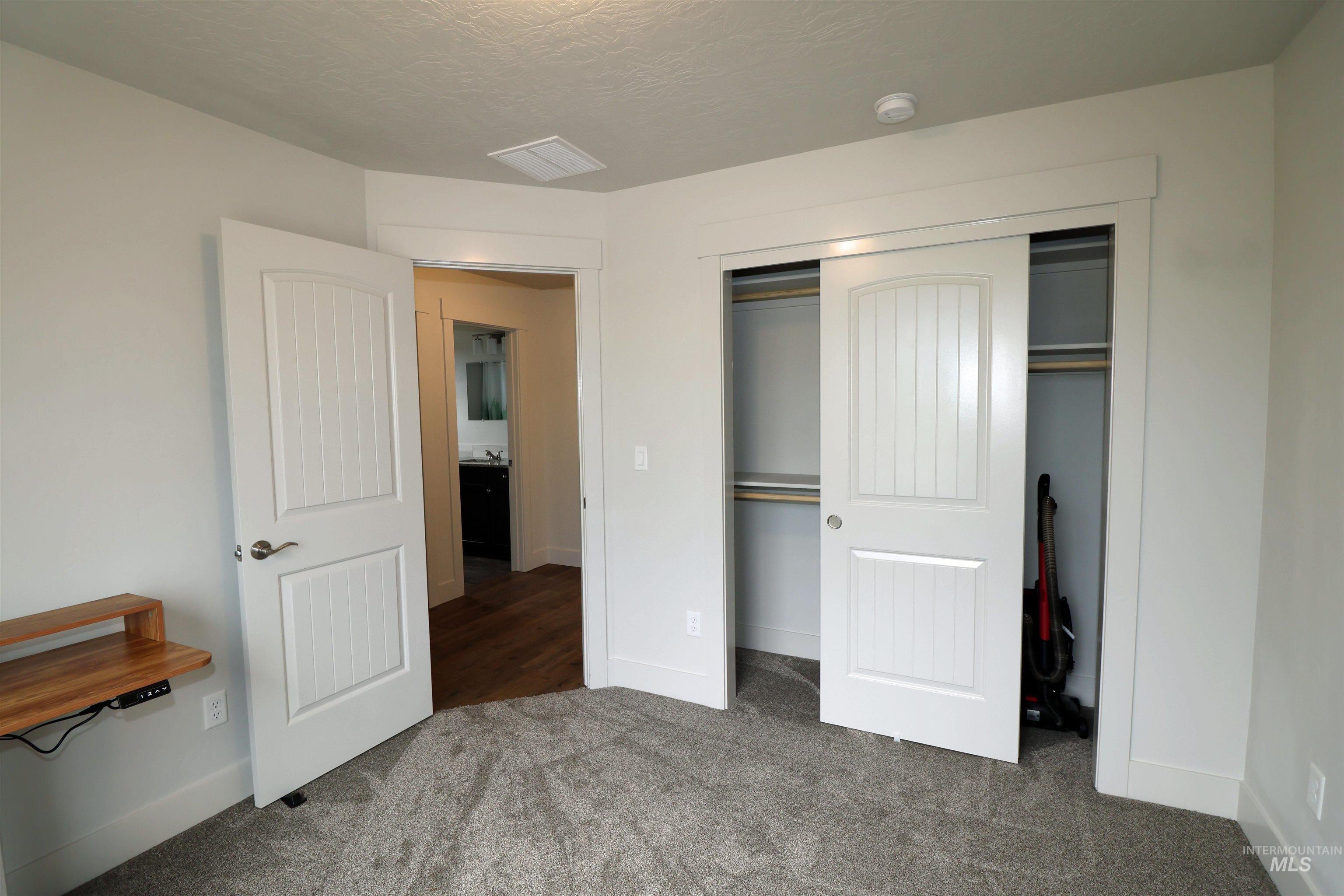 2272 Golf Lane Council, ID 83612 - Photo 22 of 32 Unfurnished bedroom with carpet, a closet, and a textured ceiling