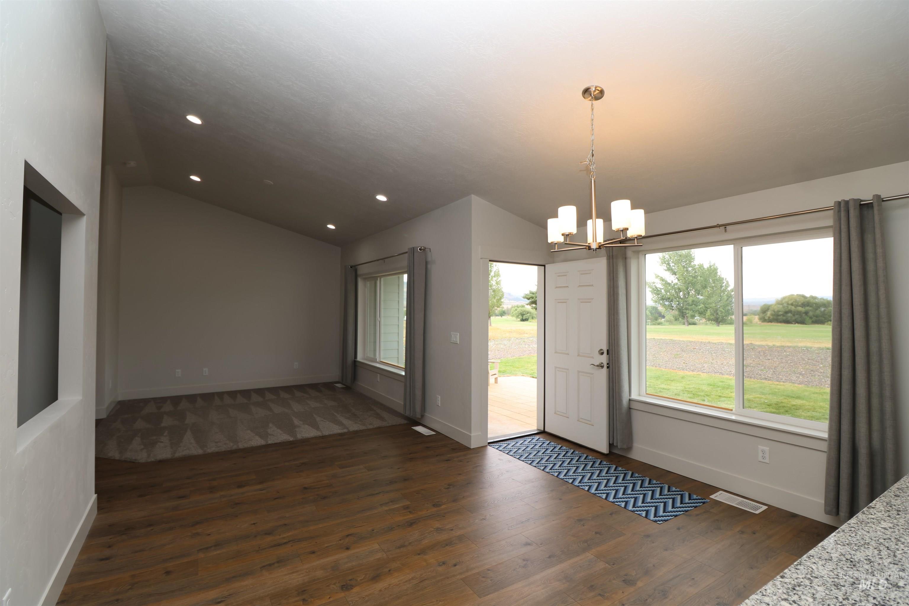 2272 Golf Lane Council, ID 83612 - Photo 9 of 32 Doorway to outside featuring vaulted ceiling, a chandelier, dark wood-style floors, and recessed lighting