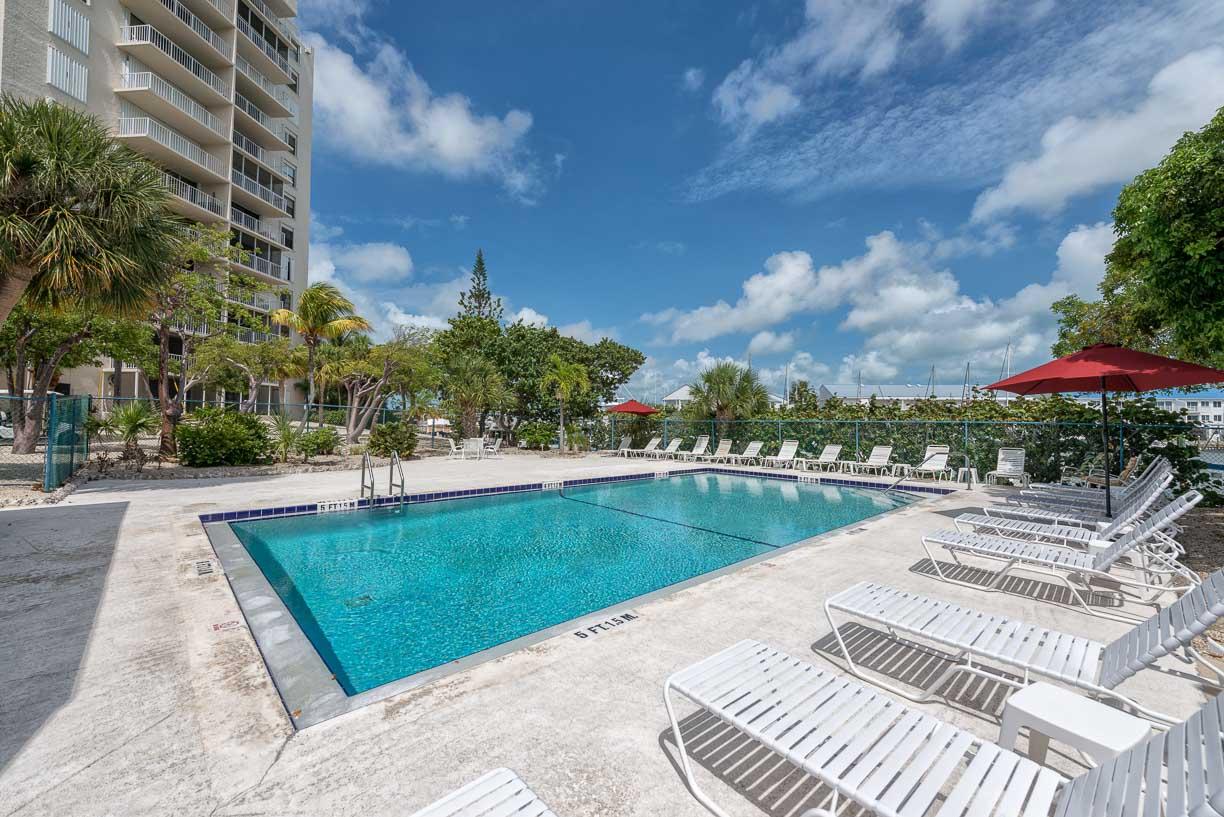 2000 Coco Plum Drive, Unit 404 Marathon, FL 33050 - Photo 11 of 23 a view of a swimming pool and trees in the background