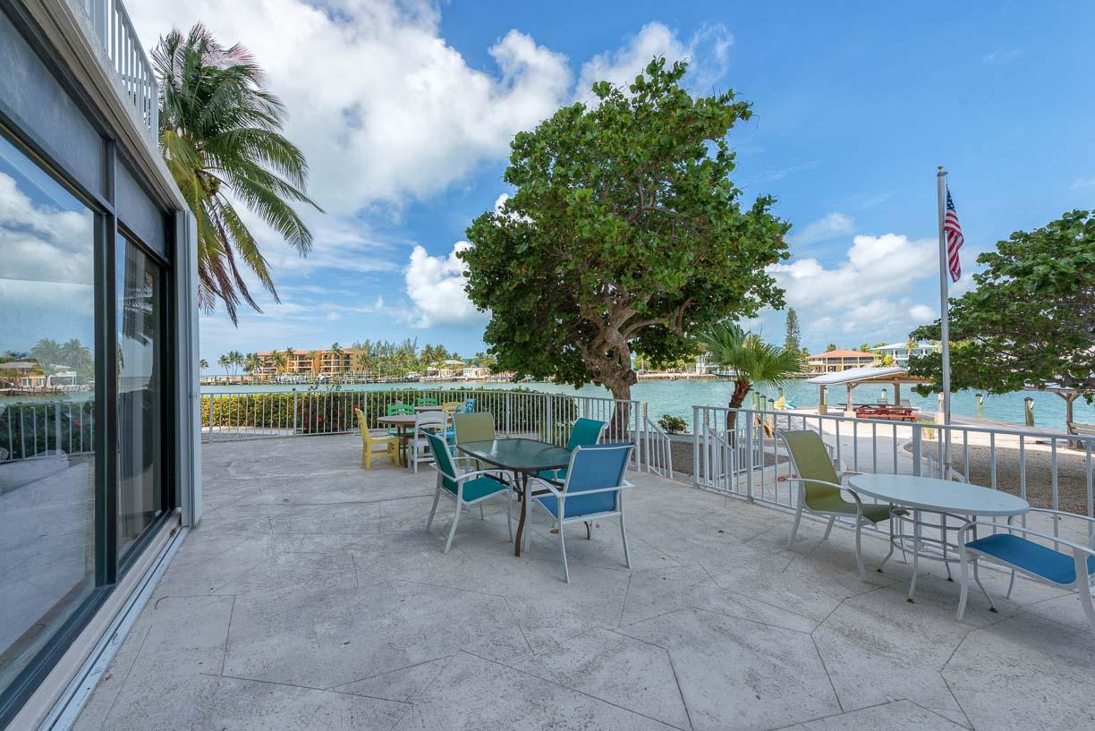 2000 Coco Plum Drive, Unit 404 Marathon, FL 33050 - Photo 17 of 23 a view of a patio with a table and chairs