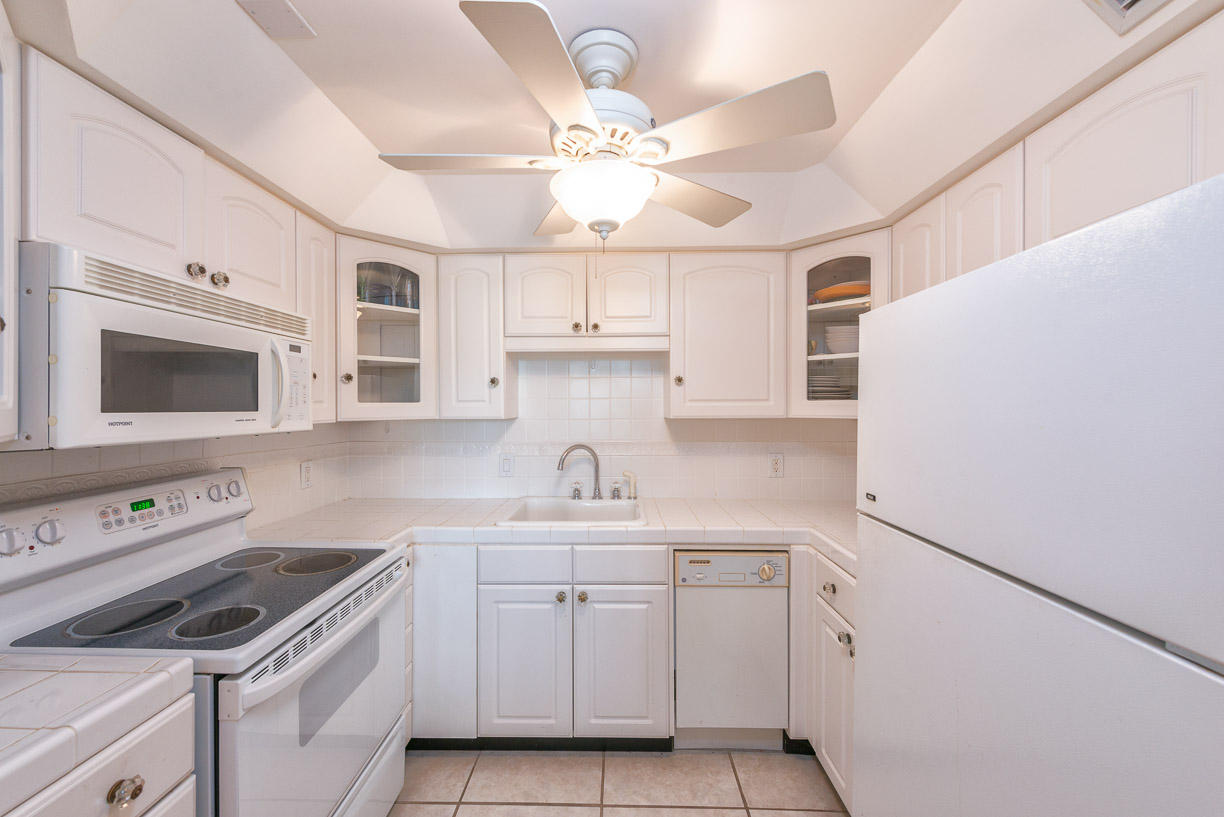 2000 Coco Plum Drive, Unit 404 Marathon, FL 33050 - Photo 5 of 23 a kitchen with cabinets stainless steel appliances and a window