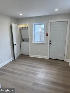a view of an empty room with wooden floor and staircase