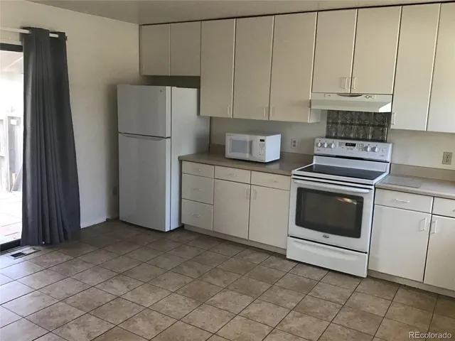 a kitchen with cabinets stainless steel appliances and a window