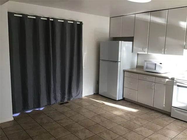 a kitchen with a refrigerator and a sink