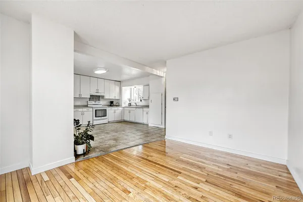 a view of a living room with kitchen island stainless steel appliances wooden floor and view living room