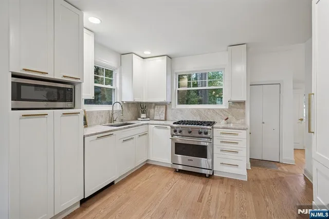 a kitchen with cabinets stainless steel appliances and window