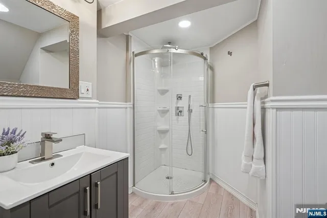 a bathroom with a shower sink and mirror
