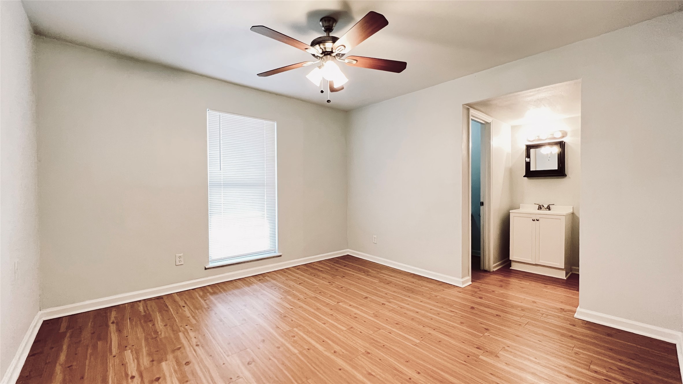2301 Ohlen Road, Unit 209 Austin, TX 78757 - Photo 6 of 10 Laminate flooring and a ceiling fan create a comfortable atmosphere in this inviting space.