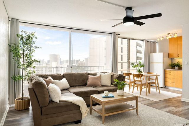 a living room with furniture and a large window with garden view