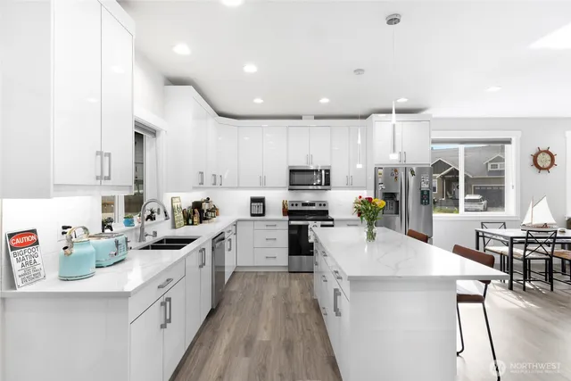 a large kitchen with stainless steel appliances lots of counter space and wooden floor