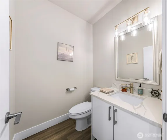 a bathroom with a granite countertop sink mirror vanity and toilet