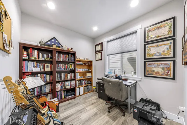 a view of a workspace with furniture and a bookshelf