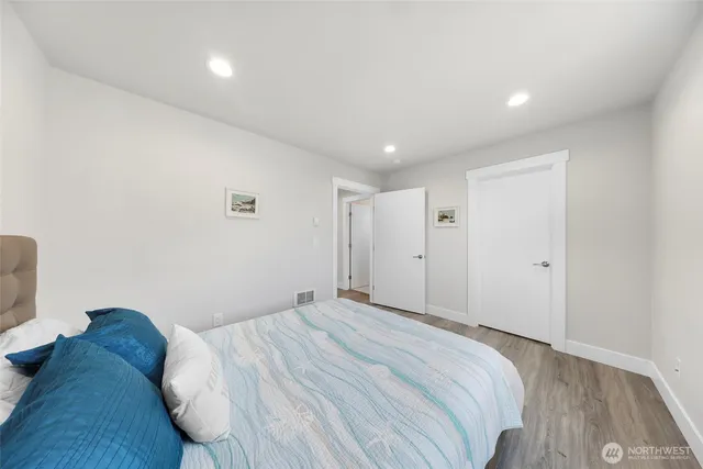 a bedroom with a bed and a wooden floor