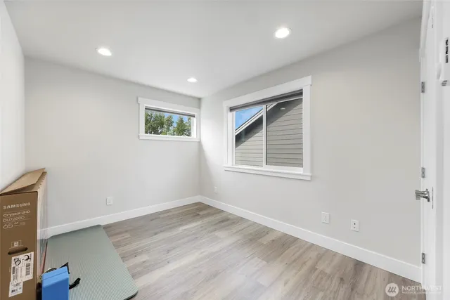 a view of empty room with wooden floor and fan
