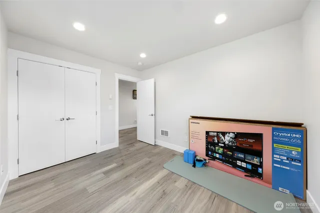 an empty room with wooden floor and a fireplace