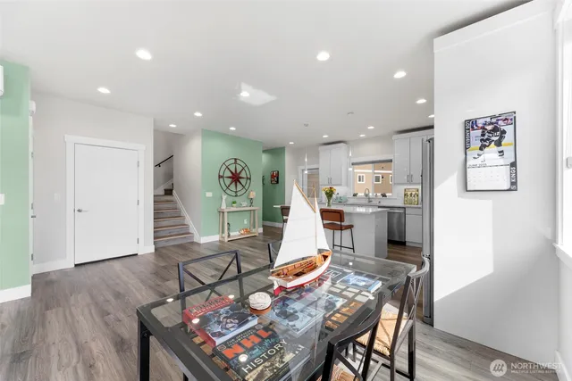 a living room with furniture and a dining table with wooden floor