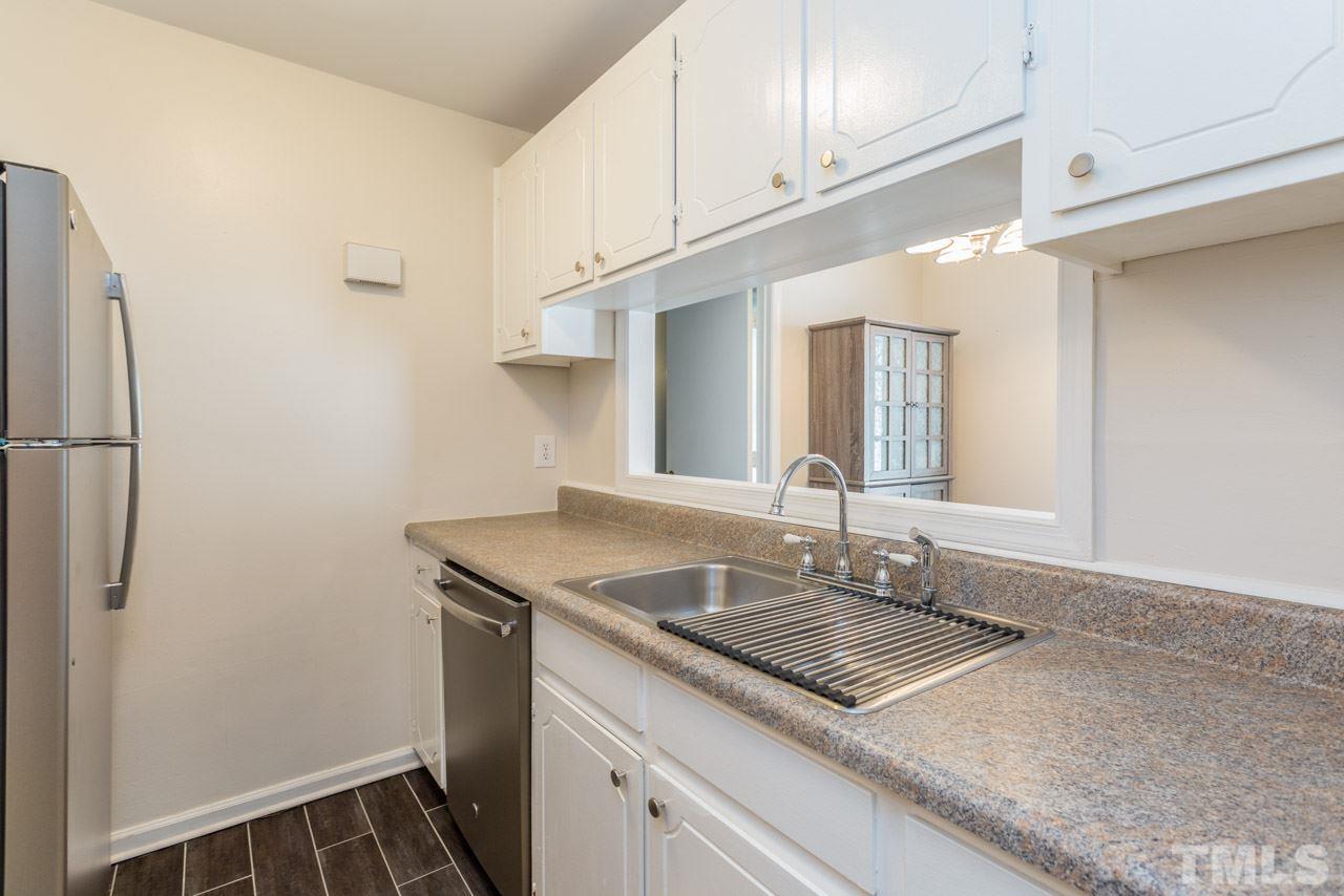3221 Mill Run Raleigh, NC 27612 - Photo 13 of 20 a kitchen with stainless steel appliances granite countertop a sink and a refrigerator