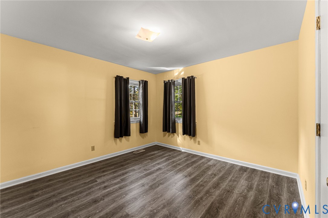 310 East Gwynnfield Road Tappahannock, VA 22560 - Photo 16 of 27 an empty room with wooden floor and windows