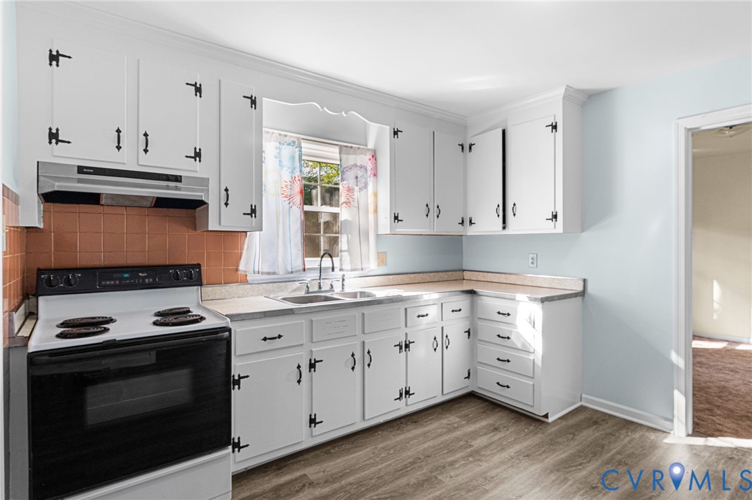 310 East Gwynnfield Road Tappahannock, VA 22560 - Photo 7 of 27 a kitchen with granite countertop white cabinets and appliances