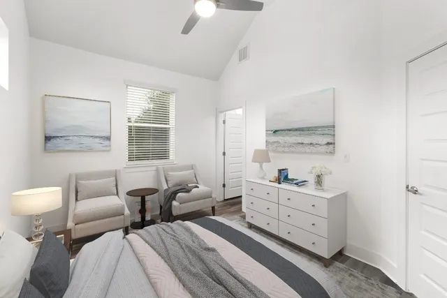 an empty room with wooden floor chandelier fan and windows