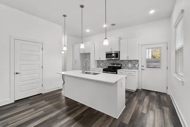 a kitchen with a sink and a stove top oven