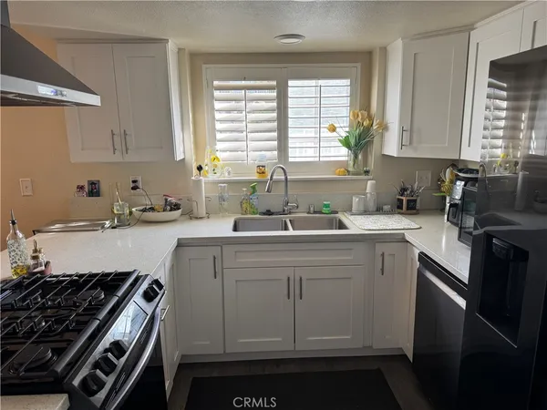 a kitchen with white cabinets and appliances