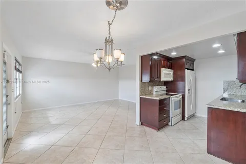 a view of a kitchen with a sink and dishwasher a stove top oven with wooden floor