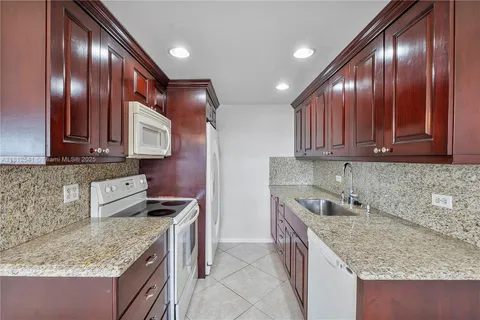 a kitchen with stainless steel appliances granite countertop wooden cabinets a sink and dishwasher