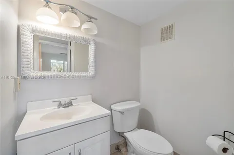 a bathroom with a sink mirror and toilet