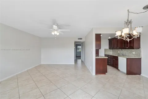 a view of a kitchen with granite countertop a sink cabinets and stainless steel appliances