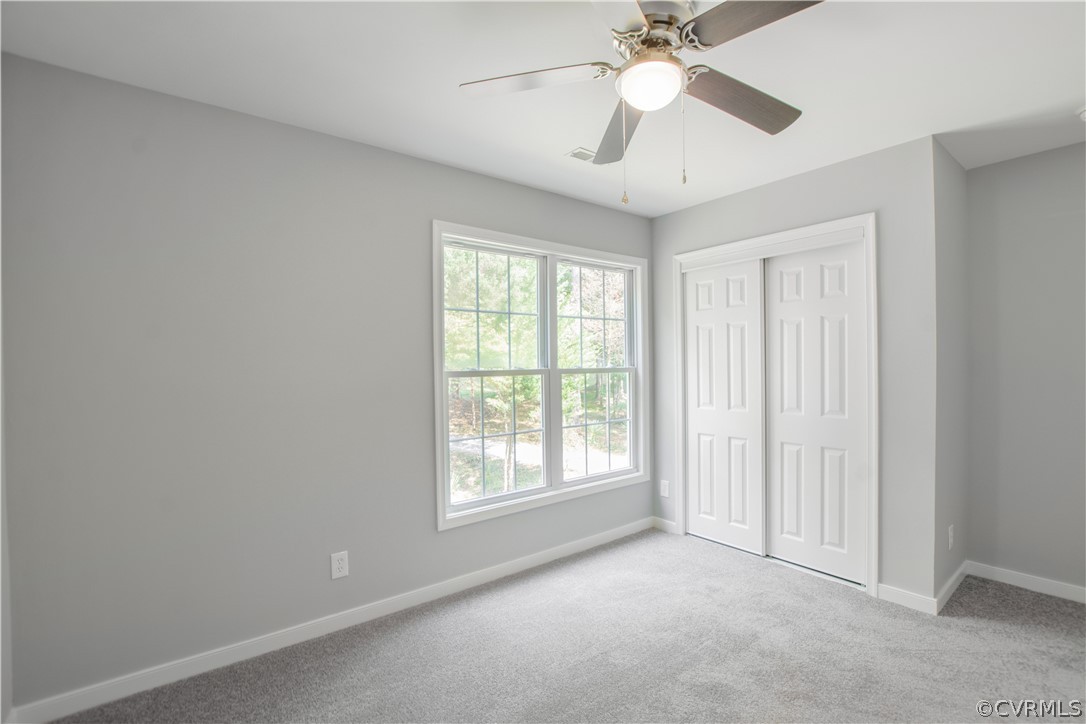 7321 Beach Road Chesterfield, VA 23831 - Photo 17 of 25 an empty room with a chandelier fan and windows
