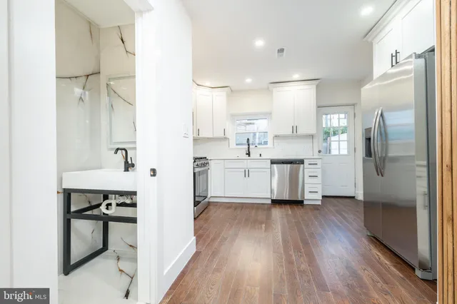 a kitchen with white cabinets and stainless steel appliances