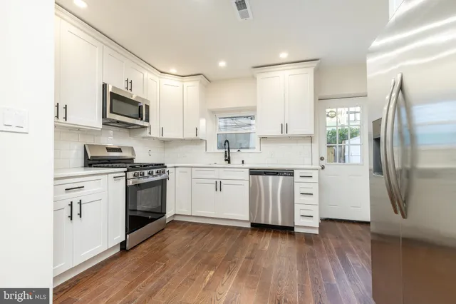 a kitchen with stainless steel appliances a refrigerator sink and microwave