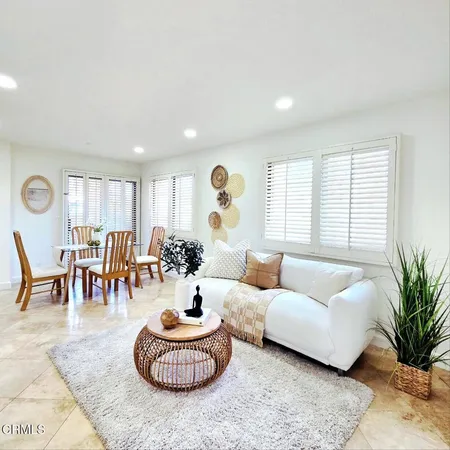 a living room with furniture potted plant and a large window