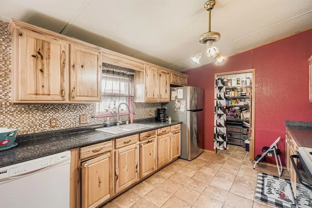 a kitchen with granite countertop a sink stainless steel appliances and cabinets